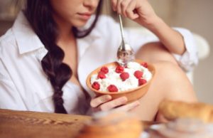 Девушка ест творог