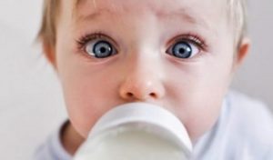 Ребенок пьет из бутылочки