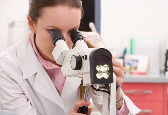 Врач смотрит в микроскоп