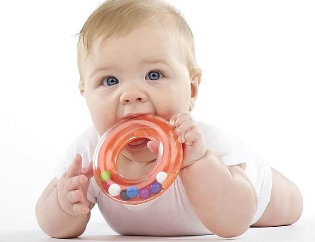 Ребенок с погремушкой во рту