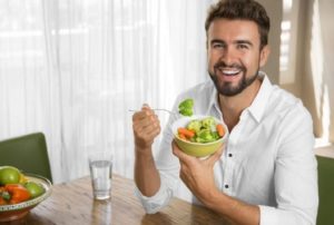Мужчина ест салат