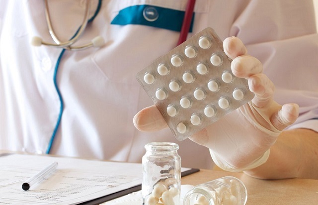 Врач держит в руках таблетки