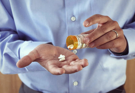Мужчина принимает таблетки
