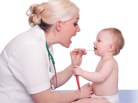 Врач обследует полость рта у ребенка