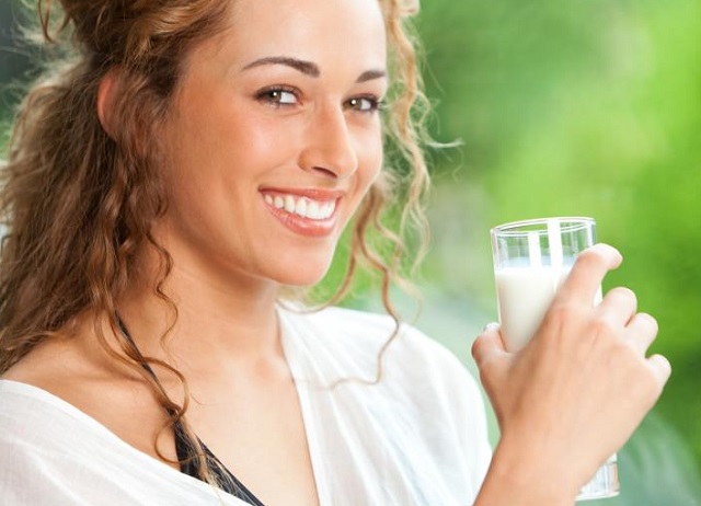Девушка держит стакан с кефиром